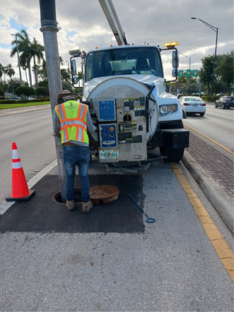 Shenandoah worker dropping pipe down a manhole
